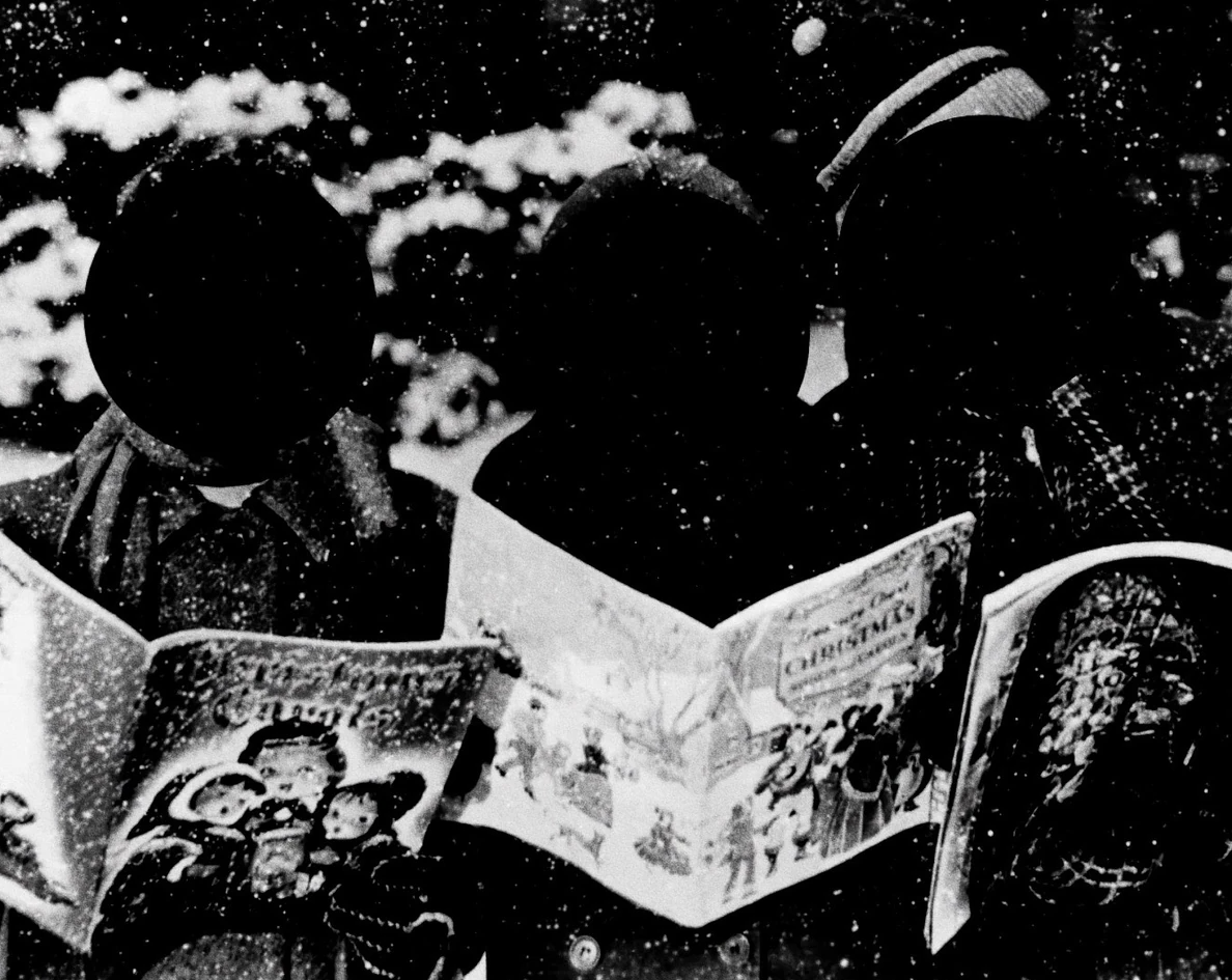 black and white image of carolers with blacked out faces holding song books
